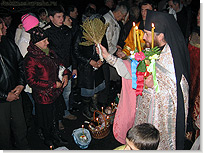 Отец Никодим освящает пасхальные приношения. <Нажмите, чтобы увеличить>